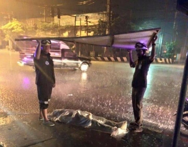 ภาพประทับใจ 2 กู้ภัยช่วยดูแลร่างผู้เสียชีวิต ขณะฝนตกหนัก 